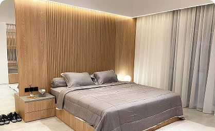 Interior kamar tidur utama bernuansa kayu dan pencahayaan hangat